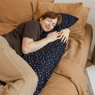 Pregnant woman hugging long maternity and lumbar support pillow for comfortable sleep