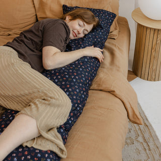 Expecting mother using full body pregnancy pillow for side sleeping support