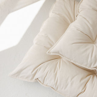 Close-up of a two beige mattresses with a neutral background