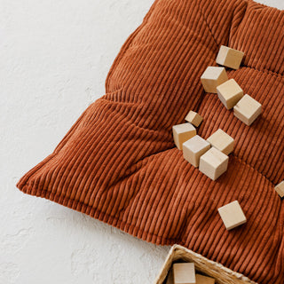 Brown corduroy textured fabric with wooden blocks on a light background